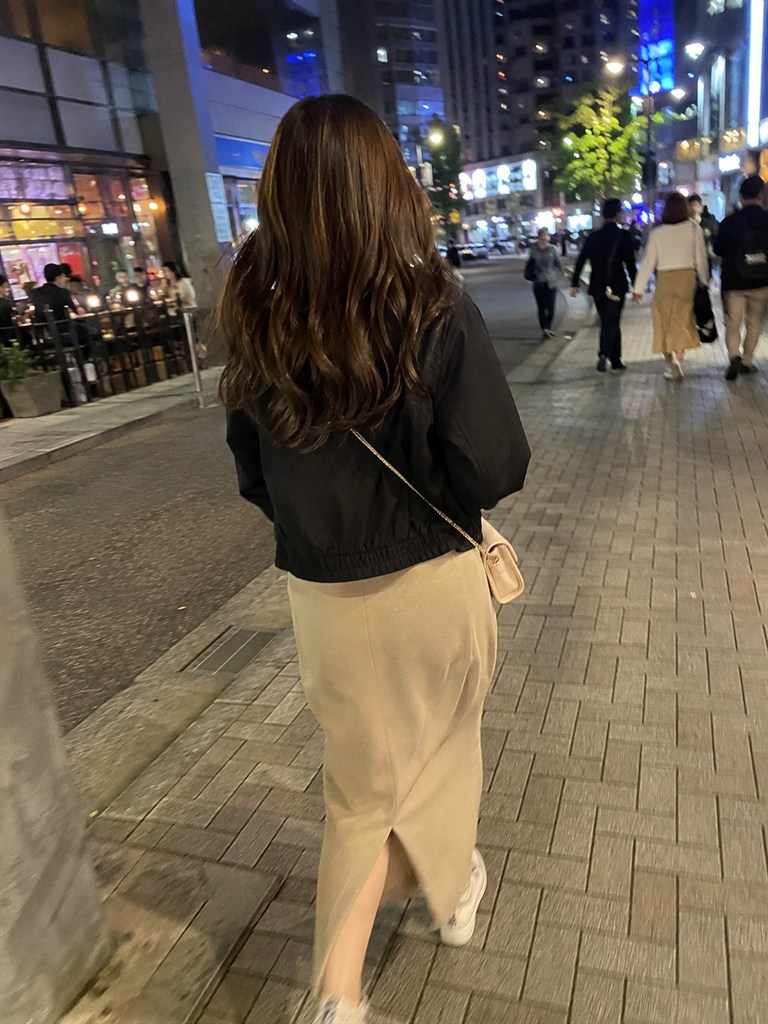 ティンダーで会った女性の後ろ姿、夜の繁華街を歩く